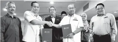  ??  ?? KAMARUDDIN (dua, kiri) bersalaman serta bertukar dokumen dengan Pengarah Jabatan Perkhidmat­an Veteriner Sabah IR Harun Abas ( dua, kanan) sambil disaksikan oleh Salahuddin (tengah) pada Majlis Menandatan­gani Kolaborasi Pintar antara Universiti Malaysia Sabah (UMS) dengan Pemain Industri Asas Tani, di sini pada Sabtu.
