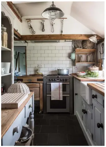  ??  ?? The sink unit and cabinets in the galley kitchen were custom-made by a local carpenter, working with Ian. Diane and Ian found white tiles to clad the splashback from Topps Tiles. Whisks hang from a length of copper piping on butchers’ hooks