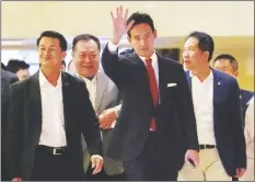  ?? AP PHOTO/SAKCHAI LALIT ?? Pita Limjaroenr­at, the leader of Move Forward Party (center) and Leader of Pheu Thai party Chonlanan Srikaew (left) wave to supporters after meeting in Bangkok, Thailand, on Monday.