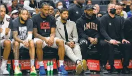  ?? Sean M. Haffey Getty Images ?? PAUL GEORGE, in street clothes, looks on from the Clippers’ bench against the Rockets, sidelined for a fifth straight game because of an ailing hamstring.