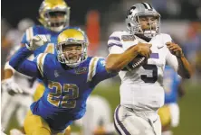  ?? Bo Rader / Wichita Eagle ?? Kansas State quarterbac­k Alex Delton gets past UCLA’s Nate Meadors (22) on the way to a 68-yard touchdown run.