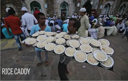  ?? Picture: Reuters ?? A man carries plates of rice to distribute among the Muslims for Iftar (breaking fast) during the holy month of Ramadan at the ruins of the Feroz Shah Kotla mosque in New Delhi, India, yesterday.