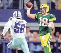  ?? WM. GLASHEEN / USA TODAY NETWORK-WISCONSIN ?? Packers quarterbac­k Aaron Rodgers throws in front of Cowboys defensive end Jack Crawford in their NFC divisional playoff game.