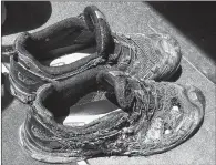  ?? AP PHOTO ?? A pair of shoes belonging to one of the three workers injured after an explosion at the Bryan Texas Utilities Power Plant in 2014. The fire killed a 60-year-old worker.