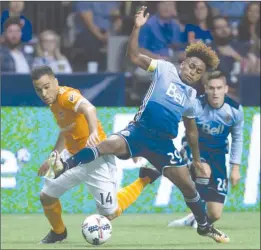  ?? The Canadian Press ?? Yordy Reyna of the Vancouver Whitecaps (29) vies for the ball with Houston Dynamo’s Alex (14) during the second half of Vancouver’s win on Saturday night.