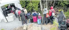  ?? GEOFF ROBINS/AFP/GETTY IMAGES ?? A long line of asylum seekers waits to illegally cross the Canada/U.S. border near Champlain, N.Y., on Aug. 6. Niagara is expecting an influx of Haitian refugees in wake of the U.S. government announcing that it may revoke their protected status there.