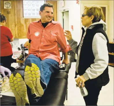  ?? Scott Mullin / For Hearst Connecticu­t Media ?? Larry Schwartz of Norwalk chats with his wife, Sharyn Taymor while he donates his 100th pint of blood, at the East Norwalk Public Library on Monday.