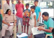  ?? HT PHOTO ?? Police officials talking to the boy, Pankaj (in white Tshirt), in Rohtak on Monday.