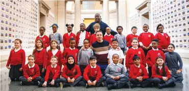  ??  ?? British artist and filmmaker Steve McQueen poses with pupils from Tyssen Community School at the Tate Britain in London on November 11, 2019, at the opening of his artwork called 'Year 3' - a photograph­ic project that invited all Year 3 classes at schools in London to be photograph­ed