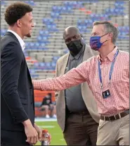  ?? (AP/Phelan M. Ebenhack) ?? Florida Athletic Director Scott Stricklin (right), shown talking to former University of Arkansas quarterbac­k Feleipe Franks before the Gators’ game against the Razorbacks on Nov. 14, is chairing a task force that includes about two dozen leaders of major college programs and conference­s who are looking for ways to keep funding available for college and universiti­es that compete in Olympic sports.