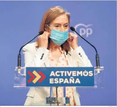  ?? PARRA / E. P. ?? Ana Pastor se retira la mascarilla antes de ofrecer una rueda de prensa en la sede nacional del PP.
