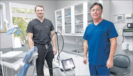  ?? BEN HASTY — READING EAGLE ?? Dr. Jon Angstadt and Dr. Eric R. Angstadt stand next to the Waterlase laser at Angstadt Family Dental in Wyomissing.