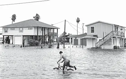  ?? COURTNEY SACCO/CORPUS CHRISTI CALLER-TIMES ?? A boy rides down a flooded street in Rockport, Texas. Gov. Greg Abbott issued a disaster declaratio­n for 29 counties.