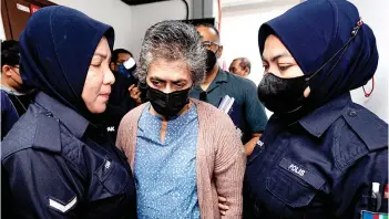  ?? — Bernama photo ?? Esther Christina escorted by police at the Sessions Court in Ipoh.