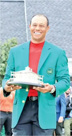  ?? — AFP photo ?? Tiger Woods of the United States wears The Green Jacket and holds The Masters Trophy after his historic one shot win during the final round of the 2019 Masters Tournament at Augusta National Golf Club on April 14, 2019 in Augusta, Georgia.