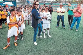  ??  ?? Gabriela Chávez, gerente de Mercadeo de EL HERALDO, entrega uno de los balones a un escolar de la Escuela República de Panamá.