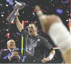  ?? RONALD MARTINEZ / GETTY IMAGES FILE ?? Tom Brady holds the Vince Lombardi Trophy aloft in February 2017 after the New England Patriots mounted an improbable comeback to beat the Atlanta Falcons.