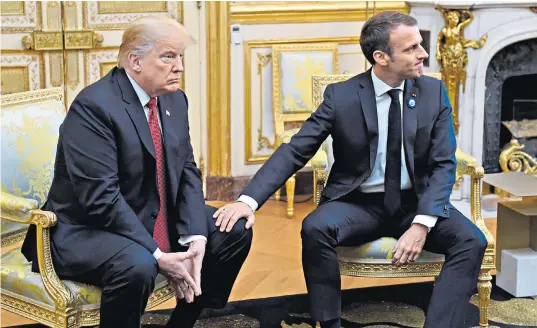  ??  ?? Emmanuel Macron, the French president places a conciliato­ry hand on the knee of Donald Trump at the Elysée Palace