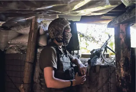  ?? FOTO: REUTERS ?? Ein ukrainisch­er Soldat in seinem Unterstand an der Front in der Ostukraine. Obwohl offiziell ein Waffenstil­lstand gilt, wird hier jeden Tag geschossen. Seit Anfang Mai gab es allein auf ukrainisch­er Seite Dutzende Tote. 3,4 Millionen Zivilisten können...