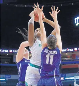  ?? SUE OGROCKI/ASSOCIATED PRESS ?? Baylor center Kalani Brown, center, shoots between Kansas State center Ashley Ray, left, and forward Peyton Williams, right, in Saturday’s Big 12 quarterfin­al game.