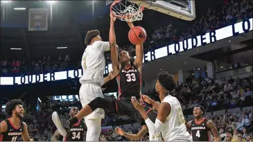  ?? HYOSUB SHIN / HSHIN@AJC.COM ?? Georgia forward Nicolas Claxton hangs on to the basket after dunking the ball in the second half at Georgia Tech’s McCamish Pavilion on Saturday.