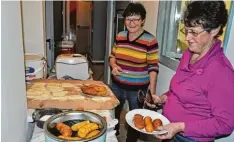  ?? Foto: Claudia Bader ?? In Teamarbeit backen Christa Menrad (rechts) und Elisabeth Neuhäusler (links) die Teigröllch­en im heißen Fett zu goldgelben Kartoffelw­ürsten.