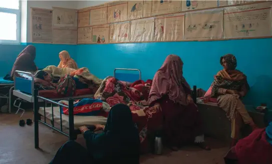  ??  ?? Ci-dessus, la salle post-accoucheme­nt de l’hôpital de Maidan Shar, occupée à la fois par des femmes qui viennent d’accoucher et d’autres en plein travail, accompagné­es de leurs belles-mères. Dans les zones pachtounes, les femmes n’ont pas le droit de se laisser photograph­ier le visage, c’est pourquoi elles tournent le dos ou se cachent derrière leur long voile.