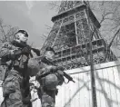  ?? BENOIT TESSIER/REUTERS ?? French soldiers patrol at the Eiffel Tower on Monday in Paris. France raised its terror alert to its highest level following Friday’s shooting in Moscow.