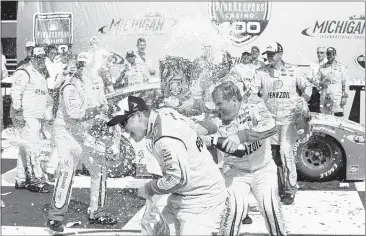  ??  ?? ASSOCIATED PRESS Joey Logano celebrates with his pit crew after winning the FireKeeper­s Casino 400 at Michigan Internatio­nal Speedway on Sunday.