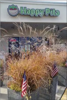  ?? PHOTO BY EMILY RYAN ?? American flags wave outside The Happy Pita in Malvern.