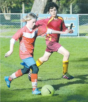  ??  ?? Drouin Dragons striker Henry Grant chases down Will Turner from Wonthaggi during the under 14 match