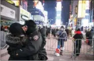  ?? THE ASSOCIATED PRESS ?? A New York police officer kisses his wife in Times Square during New Year’s Eve celebratio­ns Sunday in New York.