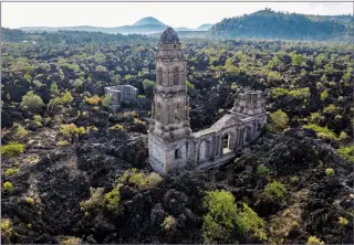  ?? (AP/Eduardo Verdugo) ?? A church tower on Feb. 21 peeks above from where lava from the Paricutin volcano buried the church decades ago in San Juan Parangaric­utiro, Mexico.