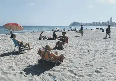  ??  ?? Sunbathers can still enjoy the sun in designated roped-off areas (photo: Denis Doyle/Getty Images)