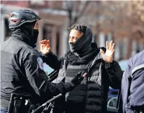  ?? JIM URQUHART • REUTERS ?? A man is searched by law enforcemen­t personnel near the statue of Confederat­e general Robert E. Lee in Richmond, Va., on Monday.