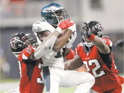  ?? JOHN BAZEMORE/AP ?? Atlanta Falcons free safety Ricardo Allen, left, and strong safety Keanu Neal sandwich Eagles wide receiver Nelson Agholor during Sunday’s game.