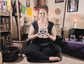  ?? PETER LEE WATERLOO REGION RECORD ?? Sherri Molloy, a modern witch, holds a sugar skull in her Kitchener home.