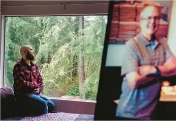  ?? DAVID GOLDMAN/AP ?? Nathan Lambrecht sits near a picture of his father, Doug Lambrecht, among the first COVID-19 victims.