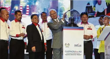  ??  ?? Move in the right direction: Najib launching the CuepacsCar­e4U campaign at Menara Miti in Kuala Lumpur. Looking on is Cuepacs president Datuk Azih Muda (third left). — Bernama