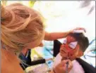  ??  ?? Amanda Wescott, left, applies a SpiderMan face painting to Joshua Ramsammy, right, at the Saratoga County Fair.