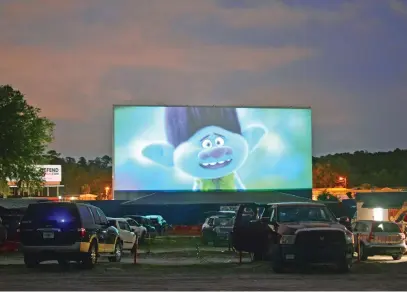  ?? Pictures: AFP ?? SOCIAL OCCASION. People watch the movie, Trolls, from their cars, separated from other cars by a 10m orange fence, at the Ocala Drive-In theatre in Florida.