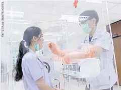  ??  ?? ABOVE
A doctor demonstrat­es how to take a sample swab while using the negative pressure booth created by Chulalongk­orn University.