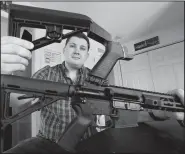  ?? AP/STEVE HELBER ?? Ryan Liskey displays a bump stock on top of his AR-15 on March 15 at his home in Harrisonbu­rg, Va.