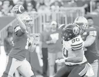  ??  ?? Blue Bombers quarterbac­k Matt Nichols unloads a pass with pressure from Argonauts lineman Cleyon Laing during the first half in Winnipeg on Friday.