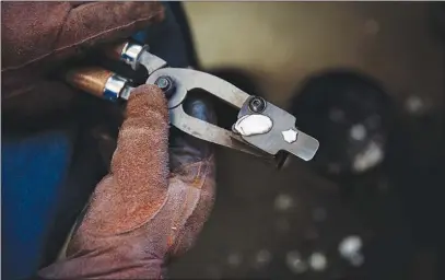  ??  ?? A freshly poured .223-caliber bullet crafted by Alexander cools in its mold.