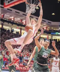  ??  ?? UNM’s Joe Furstinger, left, dunking over Colorado State’s Deion James (20), collected 13 points and four rebounds in the Mountain West Conference contest.