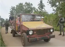  ?? — AFP ?? Philippine marines inspect a passenger jeepney at a military check point along a highway in Indanan town, Sulu province in southern island of Mindanao on Monday, after reports of the beheading of German national Jurgen Kantner by the Abu Sayyaf group.