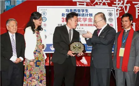  ??  ?? Working together: Dr Wee receiving a souvenir from Associatio­n of Graduates from Universiti­es and Colleges in China, Malaysia chairman Bock Chek Lim. With them are (from left) Confucian Private Secondary School board of governors chairman Datuk Ng Wee...