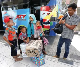  ?? RIANA SETYAWAN/JAWA POS ?? SUDAH SAMPAI: Keluarga dengan tiga anak ini baru turun dari bus yang membawa mereka dari Bojonegoro ke TOW kemarin.