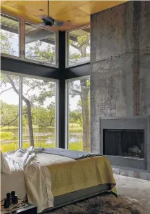  ??  ?? From top: An exterior view of Brad Nagar and Reid Sutton’s country home in Ledbetter; concrete floors and steel walls and trim flow through the dining room and beyond; the master bedroom continues the masculine and modern theme, complete with a clever...